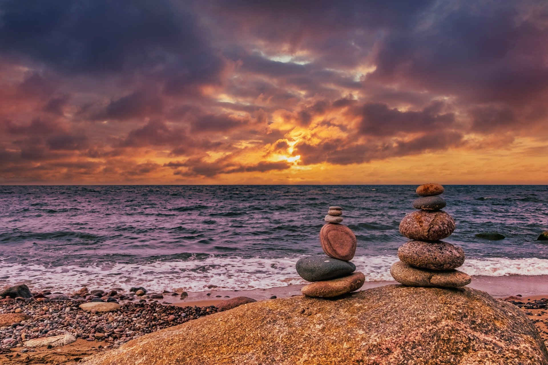 Small pebble tower on the seashore at sunset, serene coastline for relaxation and meditation